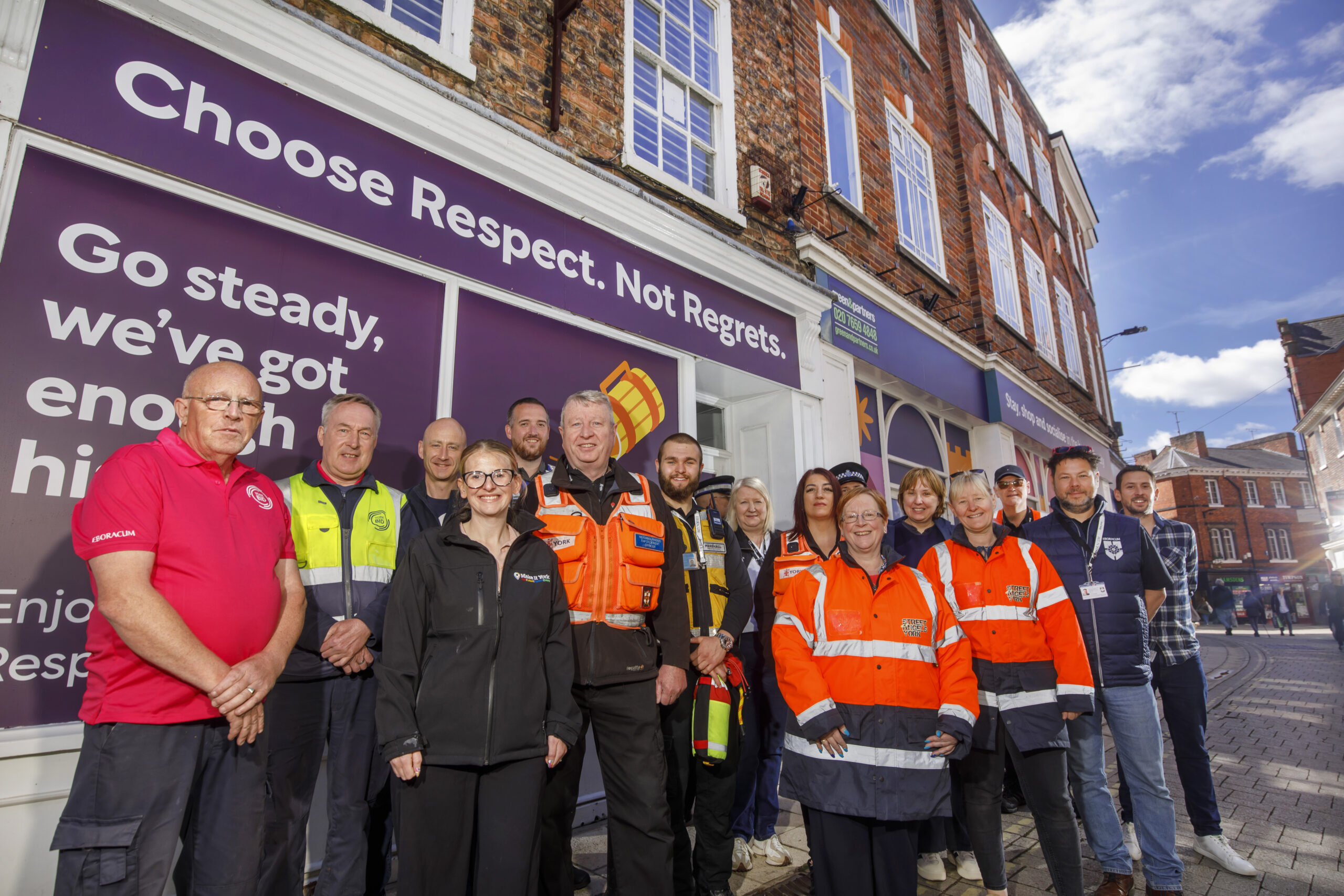 York BID and partners standing outside a 'Choose Respect, Not Regrets' shop wrap